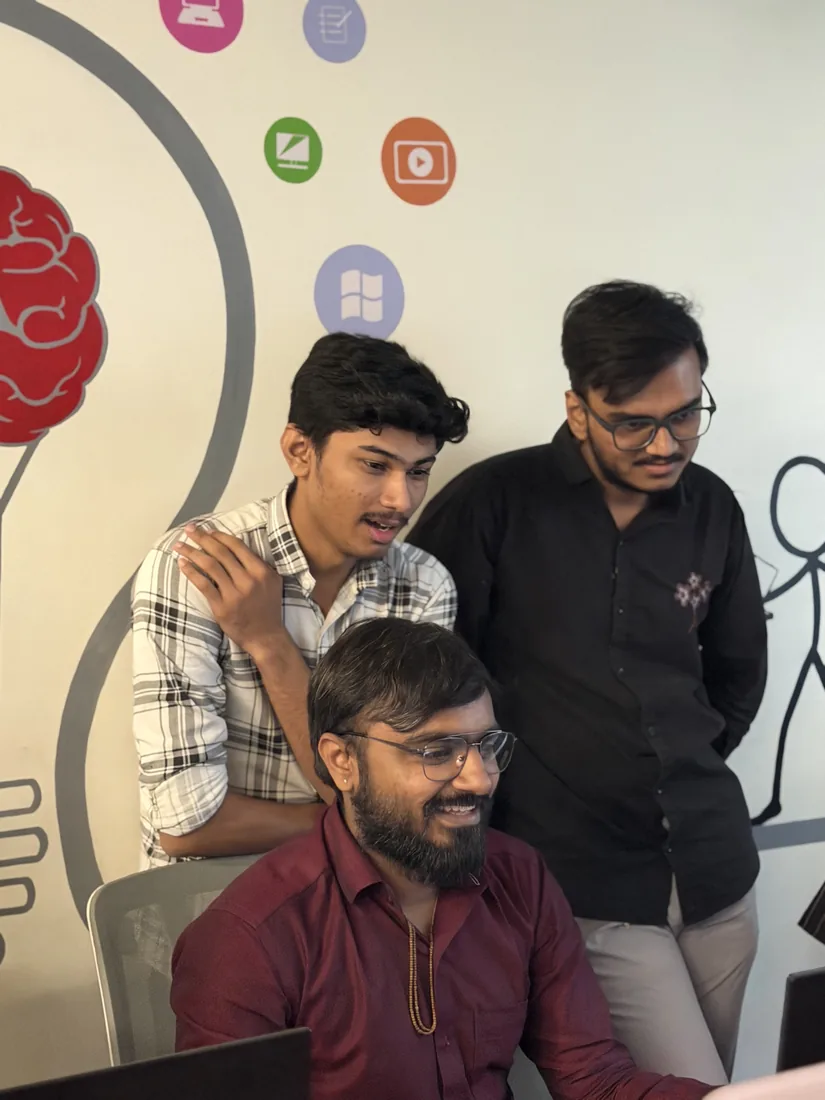 Three team members reviewing work on a screen